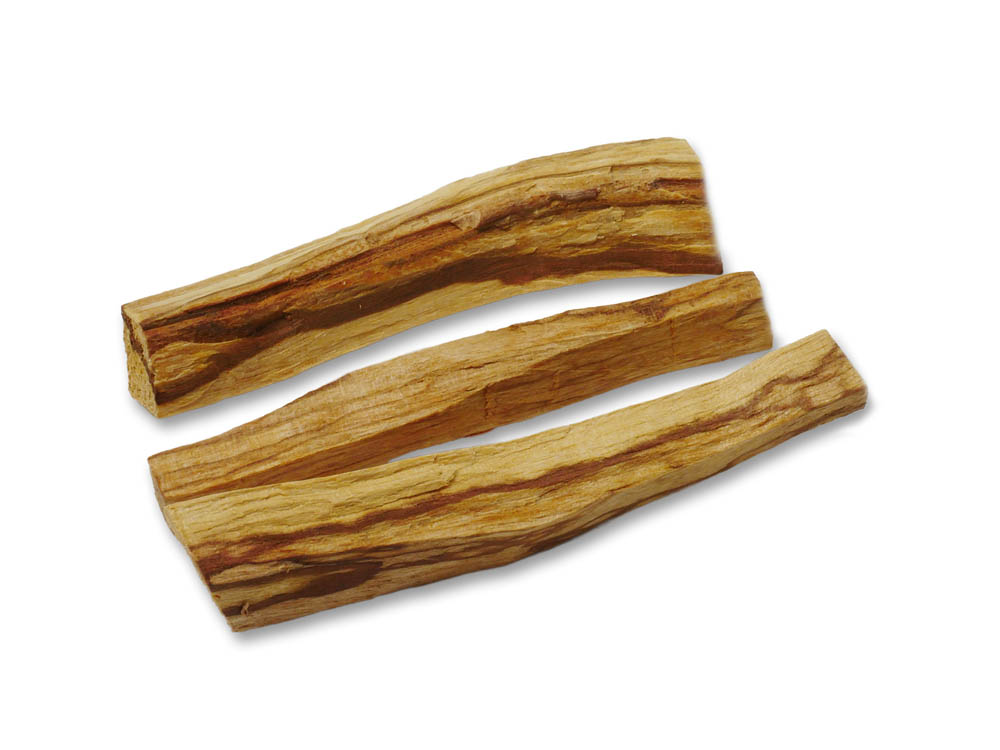 Vor weissem Hintergrund drei unregelmässige Holzstäbchen Palo Santo quer, das Holz ist hell und dunkel gestreift