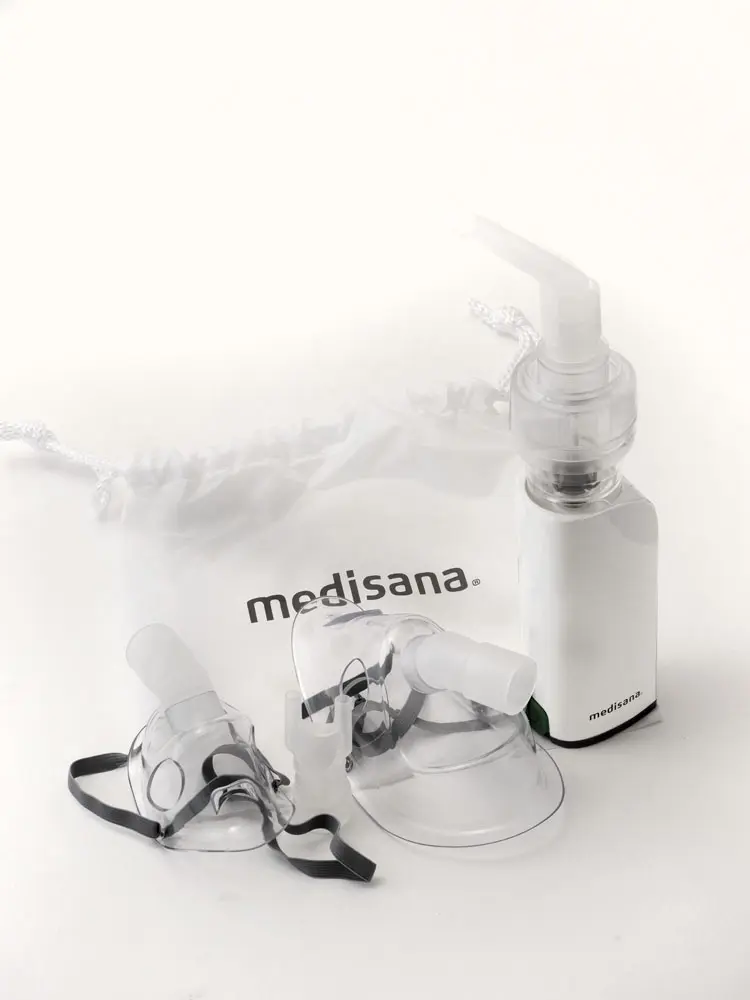 Der Inhalator mit zwei verschieden grossen Masken und einem weissen Beutel vor weissem Hintergrund