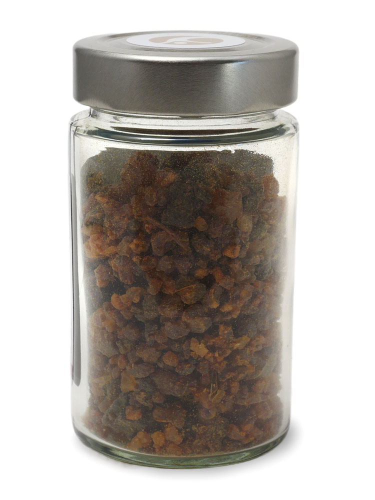 Vor weissem Hintergrund ein Schraubglas voller rot-brauner Myrrhe