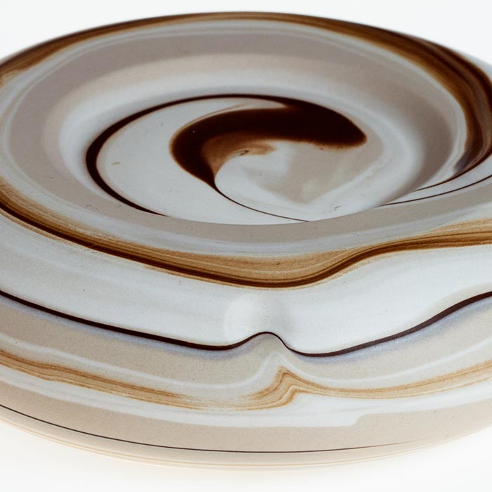 Nahaufnahme eines Keramik-Torus, um den sich rundherum Streifen in verschiedenen Brauntönen schlängeln