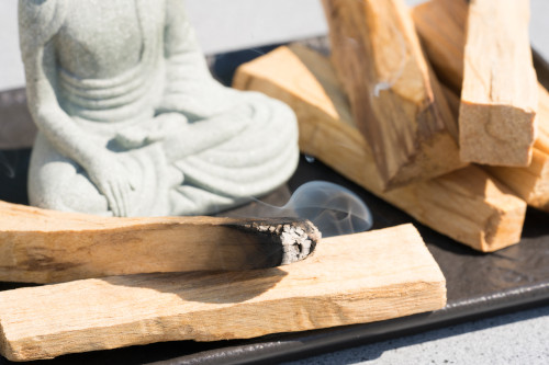 Palo Santo Holz neben einer Buddha-Statue