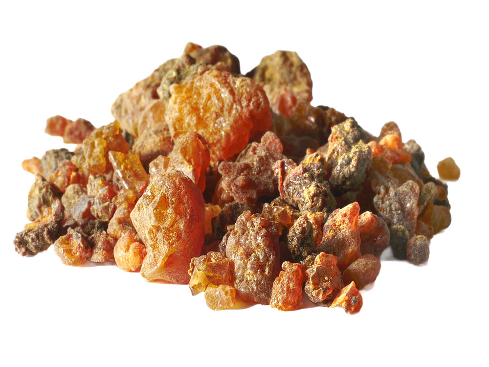 Vor weissem Hintergrund ein Haufen orange-braune Myrrhe Harzkugeln