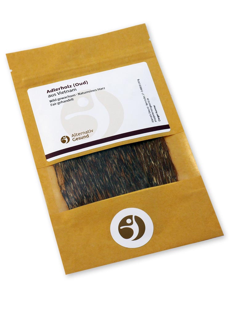 Eine beige-gelbe Papiertasche mit Sichtfenster, durch das man mehrere Adlerholz-Platten sieht