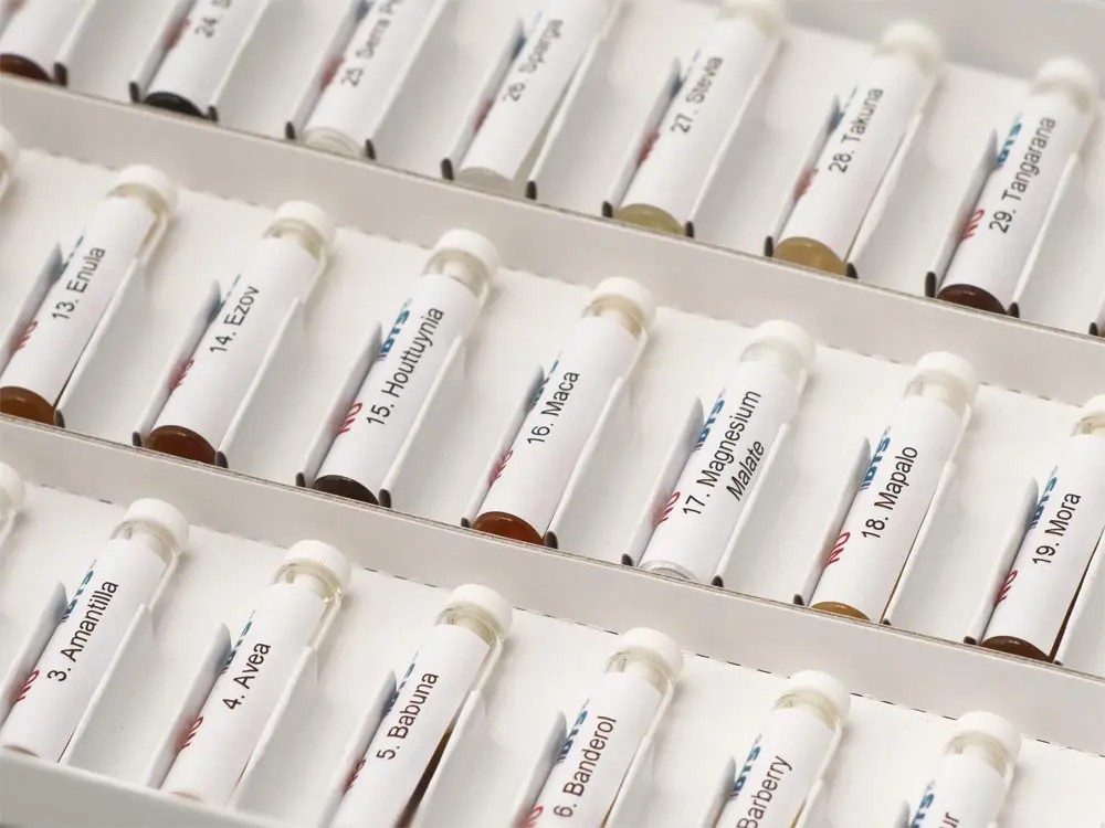Man sieht ungefähr 20 längliche Fläschchen mit NutraMedix-Mitteln, die in Reihen angeordnet sind
