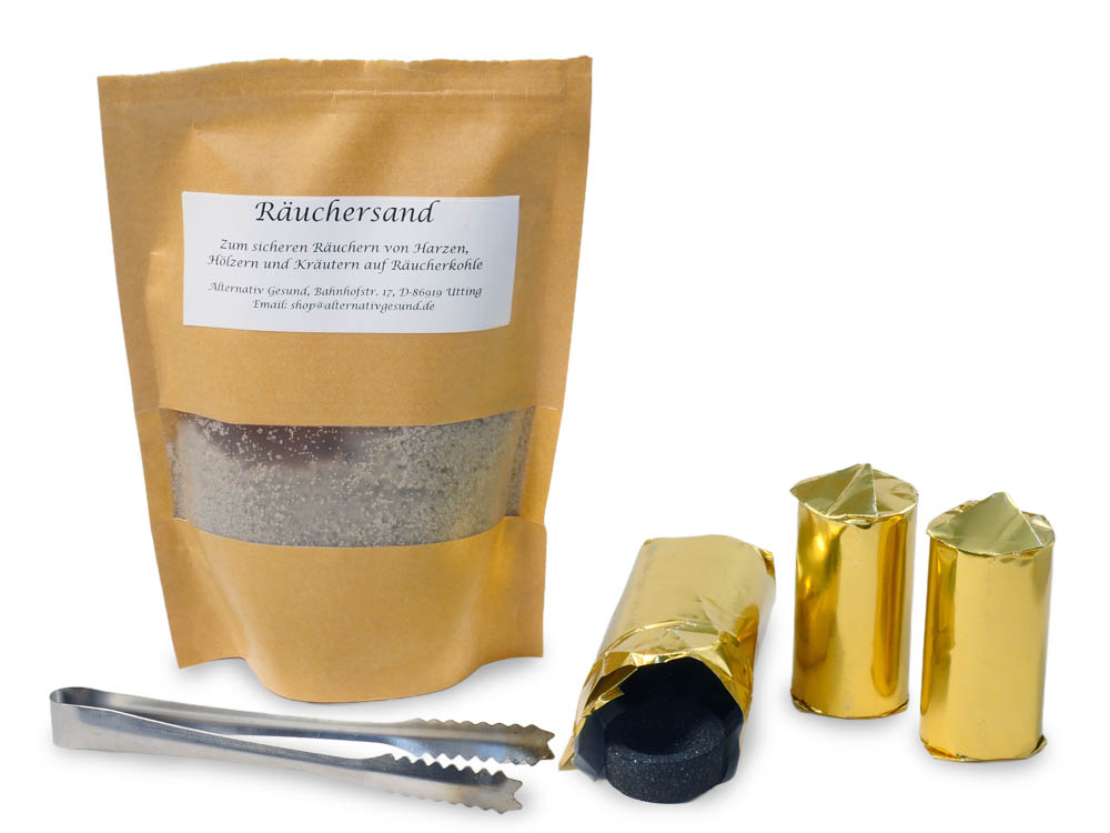 Vor weissem Hintergrund eine beige-gelbe Papiertasche mit Sand, eine Metallzange und drei Rollen mit Räucherkohle