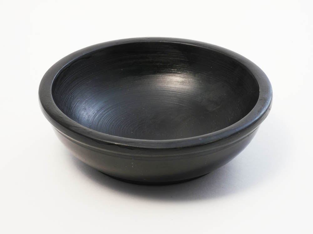 Vor weissem Hintergrund eine schwarze, formschöne Schale