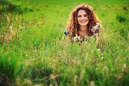 Eine gesunde, hübsche Frau liegt in einer Blumenwiese