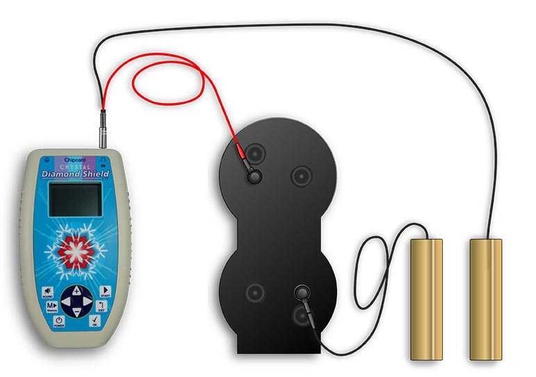 Der Fraktal-Verstärker wird zwischen das rote Kabel des Zappers und die Elektrode angeschlossen Neben dem blauen Zapper Gerät liegt der schwarze Fraktalverstärker und ist durch Kabel mit goldenen Handelektroden verbunden